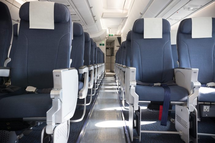 An economy class empty clean cabin of the airplane - empty dark blue chairs