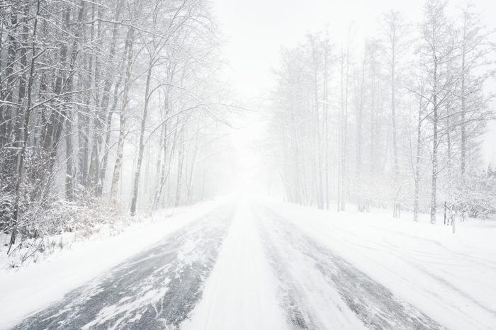 Snowy winter road during blizzard in Latvia. Heavy snow storm.