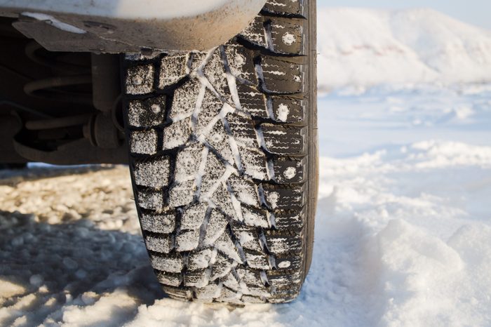 Winter studded tire on the snow .