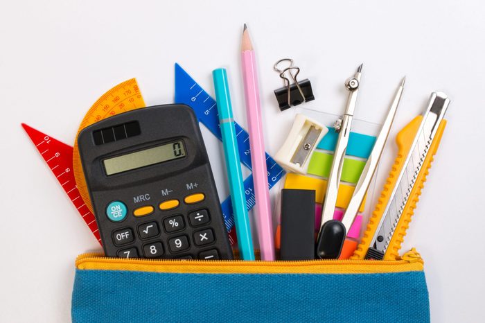 Student pencil bag or pencil case with school supplies for student on white background. Blue pencil box with school equipment for math class isolated on white background. School math equipment.