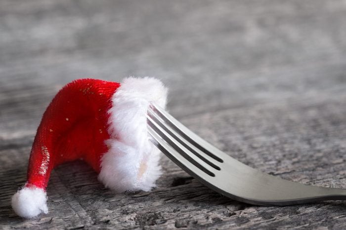 Christmas food menu abstract background with fork and santa claus hat on table