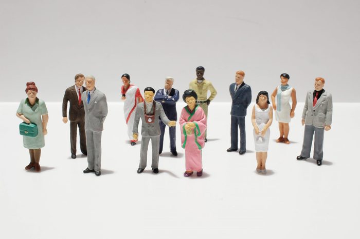 Miniature figures assembled on white and gray background