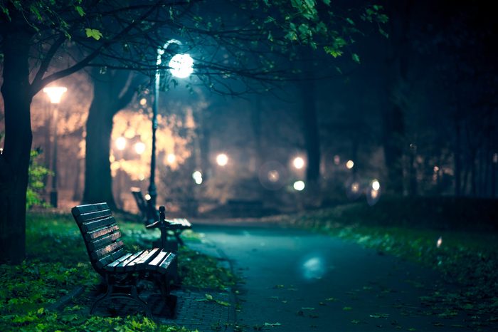park benches lit by a street lamp at night