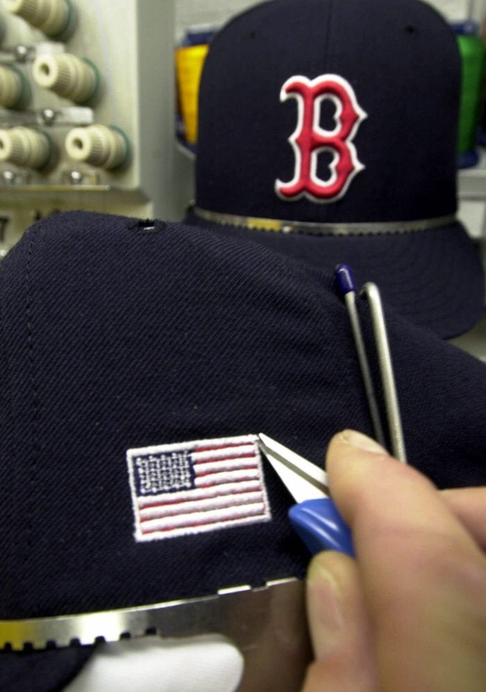 Mandatory Credit: Photo by David Duprey/AP/Shutterstock (6465200a) MAJOR LEAGUE CAPS A worker stiches an American flag into a baseball cap at the New Era Cap Company in Buffalo, N.Y., . The company is stitching American flags onto the caps of Major league baseball players to wear when play is resumed after Tuesday's terrorist attacks in New York and Washington. The cap maker's plants in Jackson, Ala., and Buffalo will handle the last-minute order from the league. Flags about an inch-high will appear on the caps' left side ATTACKS BASEBALL CAPS, BUFFALO, USA