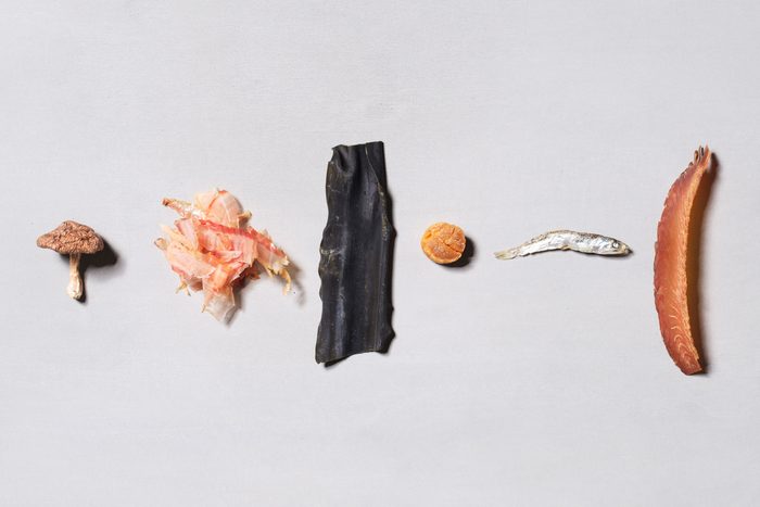 ingredients for dashi neatly arranged and aligned on a gray background