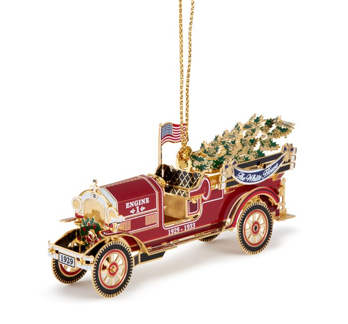 This image is the 3-Quarter Left view (with string) of the 2016 White House Christmas Ornament that honors President Herbert Hoover, the 31st President of the United States who was in office from 1929 to 1933. Inspired by the fire engines that responded to a 1929 Christmas Eve fire at the White House, the ornament also honors the toy trucks that were presented to children by the Hoovers' the following Christmas.