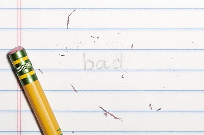 erased text "bad" with eraser shavings on loose leaf paper