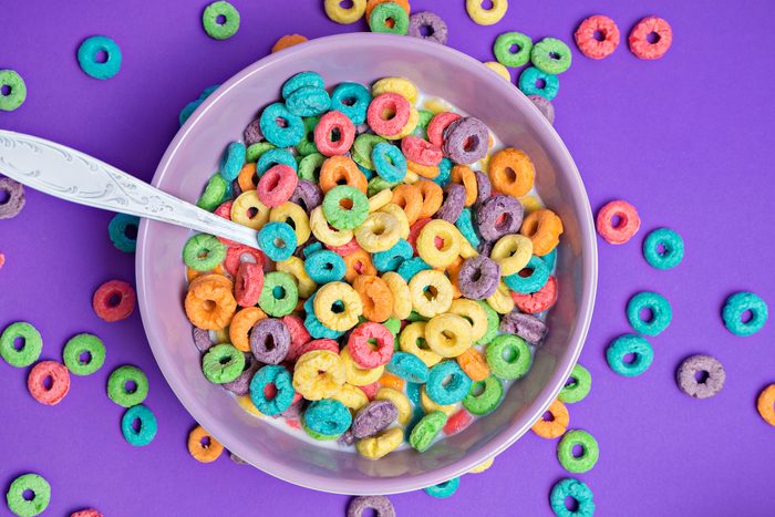 Colorful cereal in white bowl with shoon on a white background