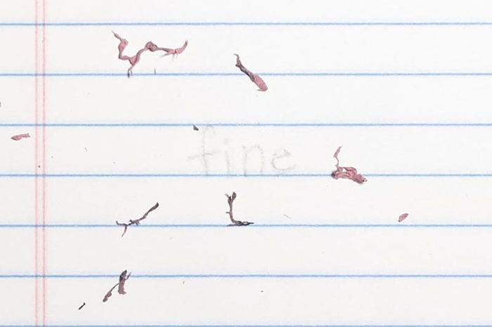 erased text "fine" with eraser shavings on loose leaf paper