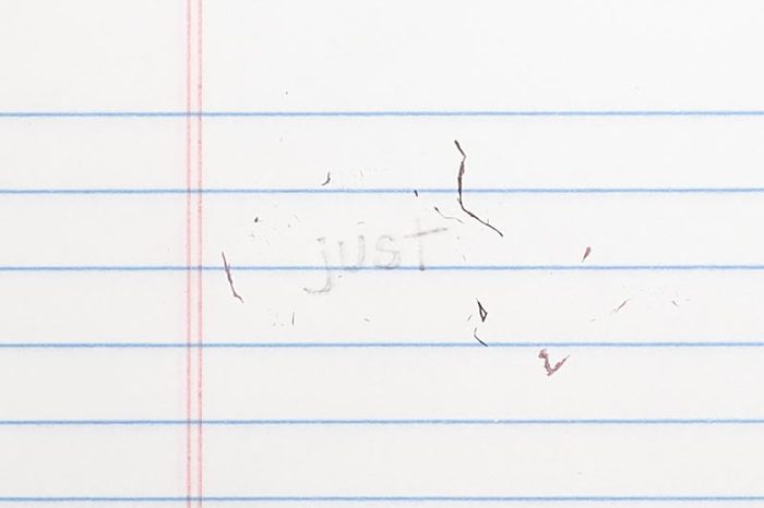 erased text "just" with eraser shavings on loose leaf paper