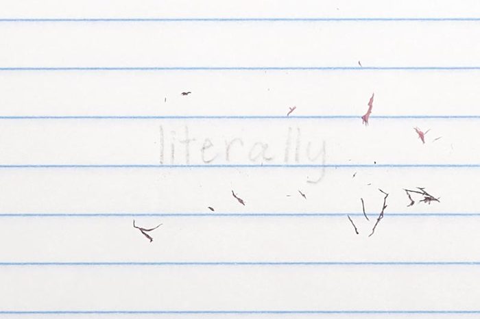 erased text "literally" with eraser shavings on loose leaf paper