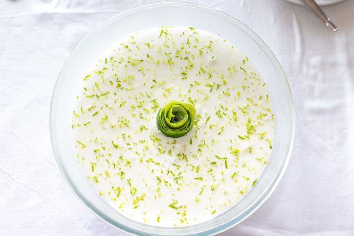 Bowl of lime mousse on table top with white towel.