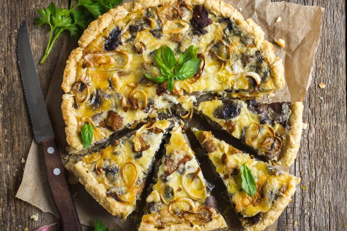 tart with mushrooms, leek and cheese on rustic background