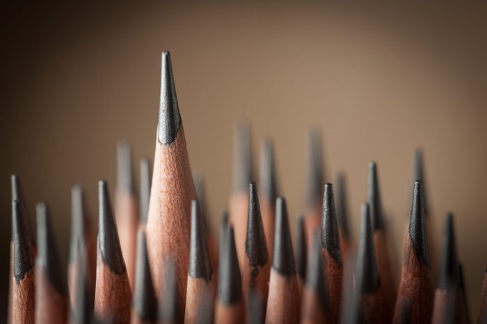 One sharpened pencil standing out from the other pencil