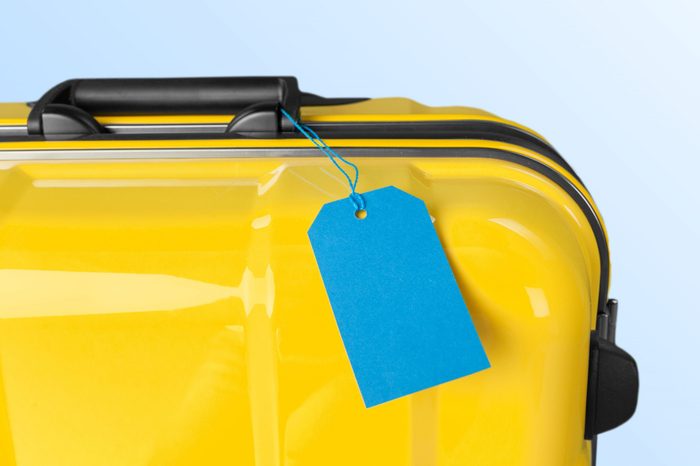Suitcase on pastel beige background