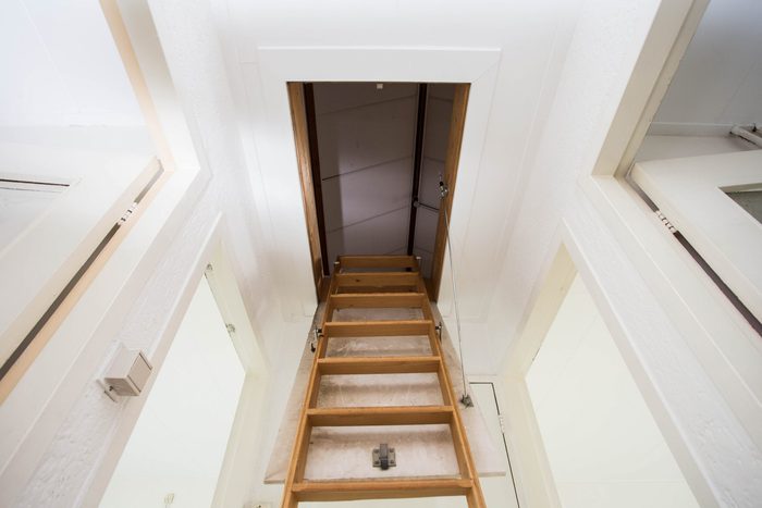 Wooden staircase to the attic in a modern house empty