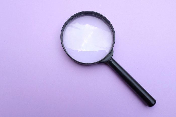 close up magnifying glass on the on a purple background