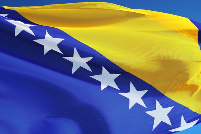 Bosnia and Herzegovina flag waving against clean blue sky, isolated with clipping mask alpha channel transparency