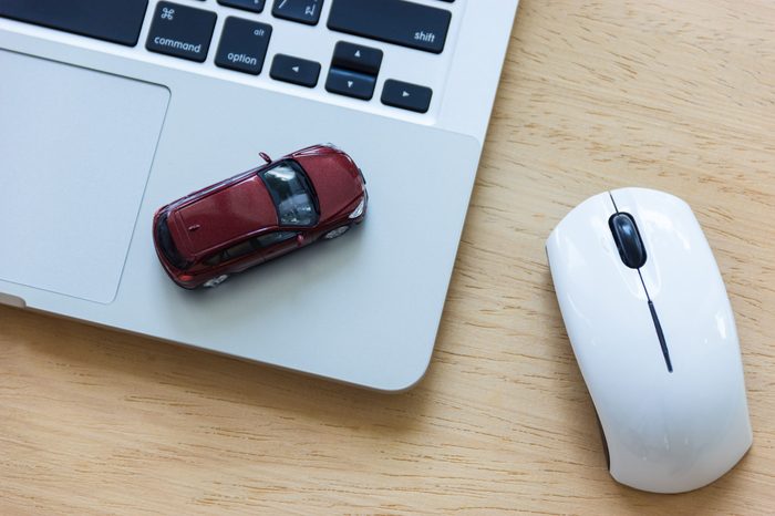Car model on notebook and mouse on wooden desk. About car business concept such as transportation, rental, sell and buy