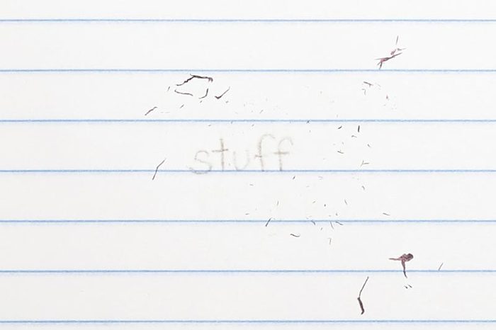 erased text "stuff" with eraser shavings on loose leaf paper