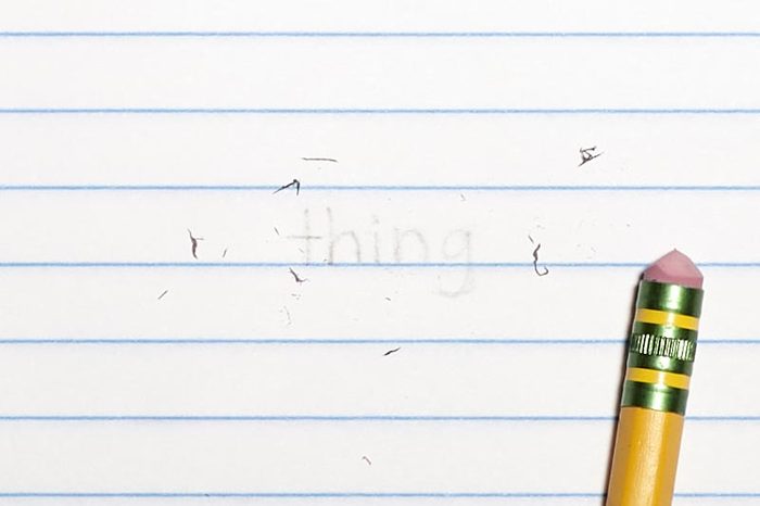 erased text "thing" with eraser shavings on loose leaf paper