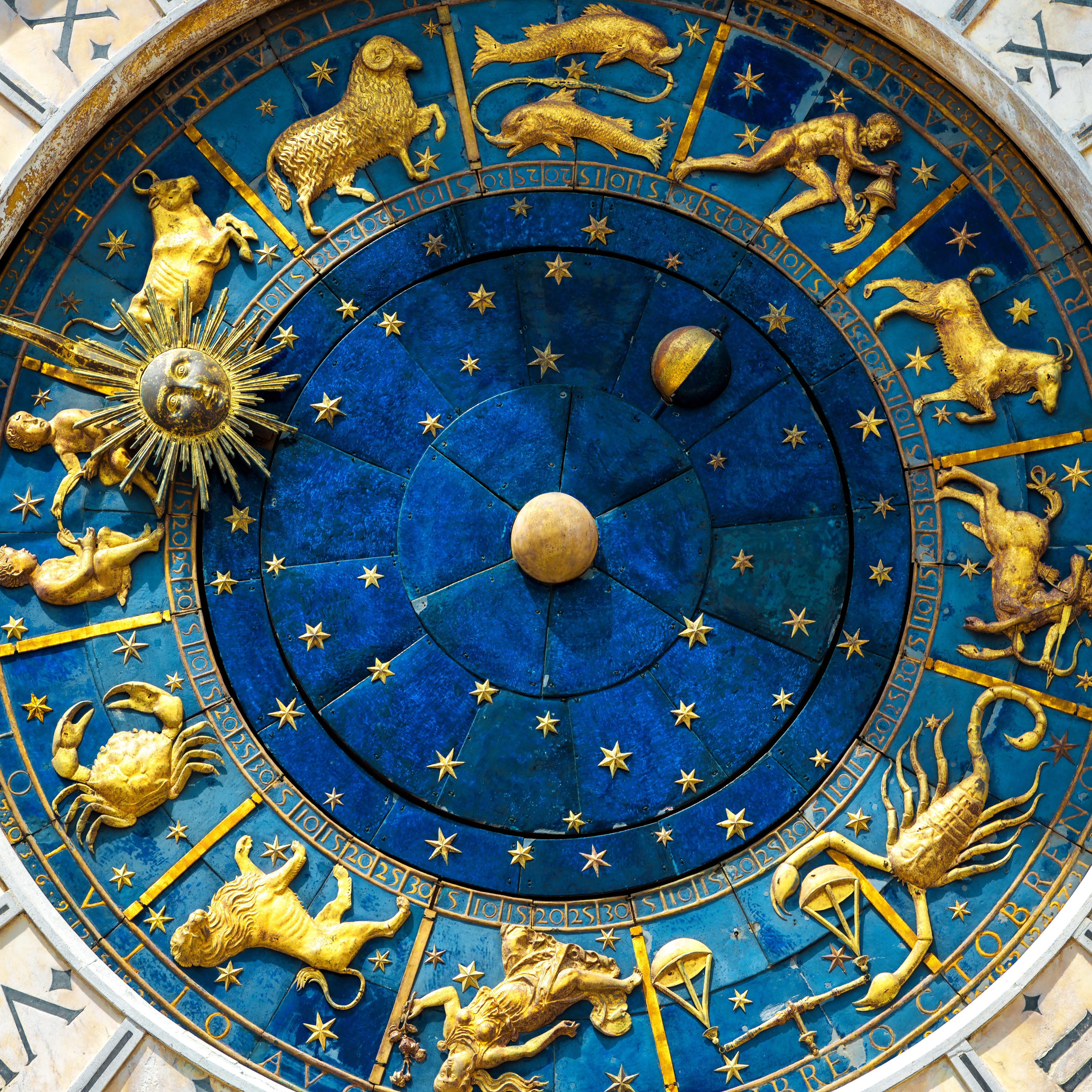 Ancient clock Torre dell'Orologio on St Mark's Square (San Marco) in Venice. Detail with clock face and astrological Zodiac signs. Vintage dial close-up, medieval art of Italy. Astrology concept.