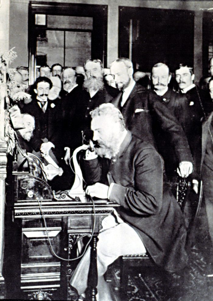 ALEXANDER GRAHAM BELL, demonstrating how to make a phone call in New York, March 12, 1876. Bell is talking to Thomas Watson & says, Mr. Watson -- Come here -- I want to see you.