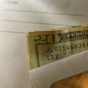 close up shot of envelope cash money tip mailman