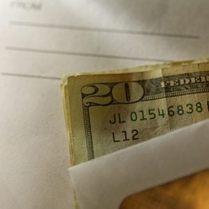 close up shot of envelope cash money tip mailman