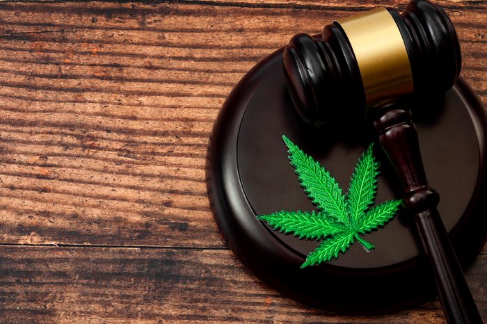 gavel and cannabis leaf patch on wood background