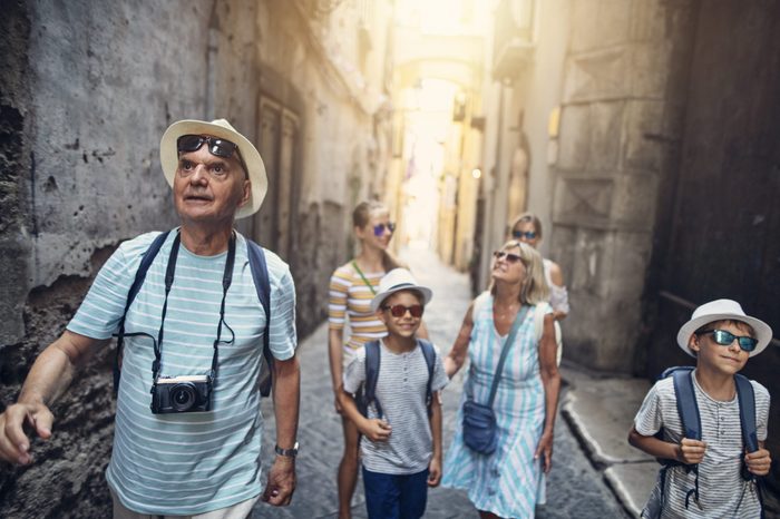 Multi generation family enjoying summer vacations. The family is walking in the narrow streets of a beautiful Italian town.