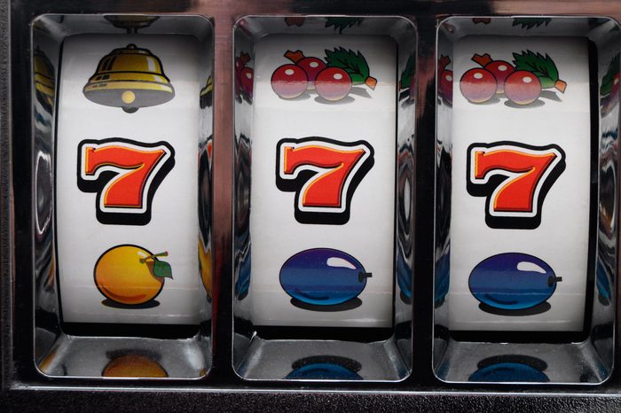 close up of slot machine with winning sevens