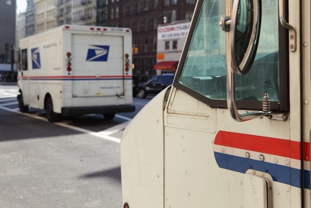 two usps trucks parked on the street