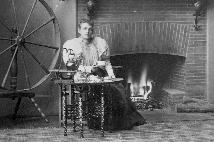 Frances Benjamin Johnston seated by the fireplace in her studio, circa 1880