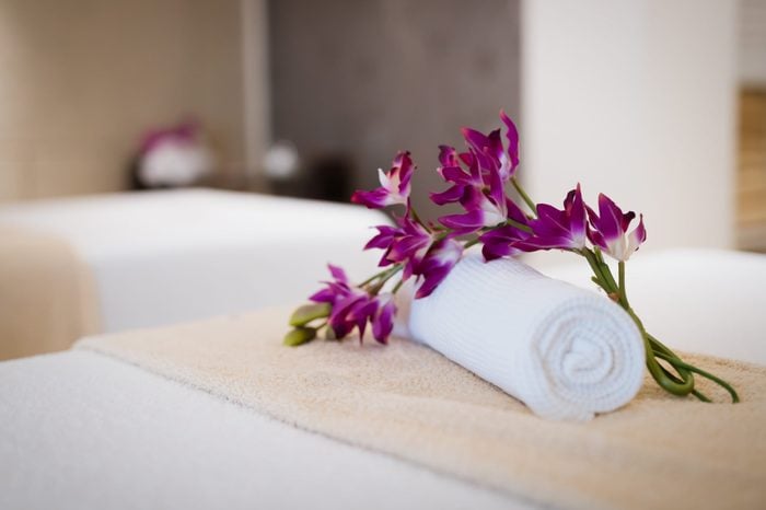 flower on a rolled towel on a massage table in a spa