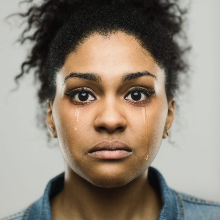 Close-up portrait of sad young afro american woman crying tears