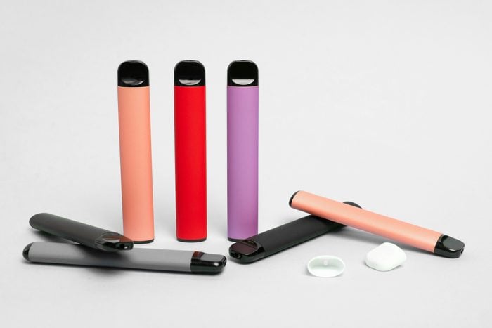 a variety of colored e-cigarettes on a gray background