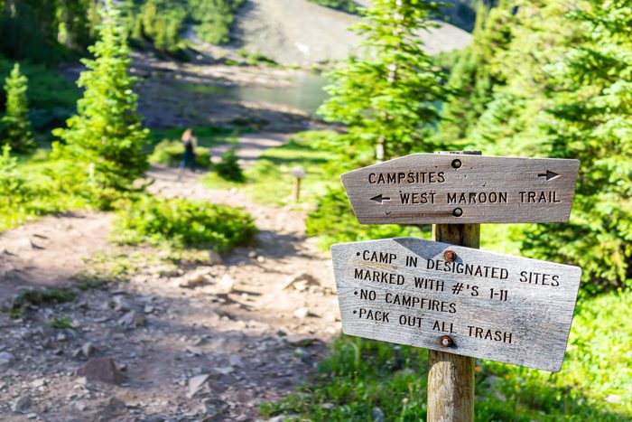 Maroon Bells trail direction sign for campground in Aspen, Colorado in July 2019 summer on path road closeup view