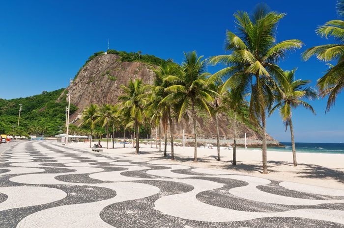 Leme and Copacabana beach with palms and mosaic of sidewalk in Rio de Janeiro