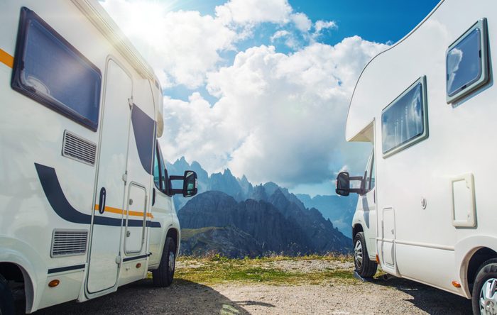 High Mountain Campers Camping. Two Motorhomes and the Scenic Mountain View. Outdoor and RVing Theme.