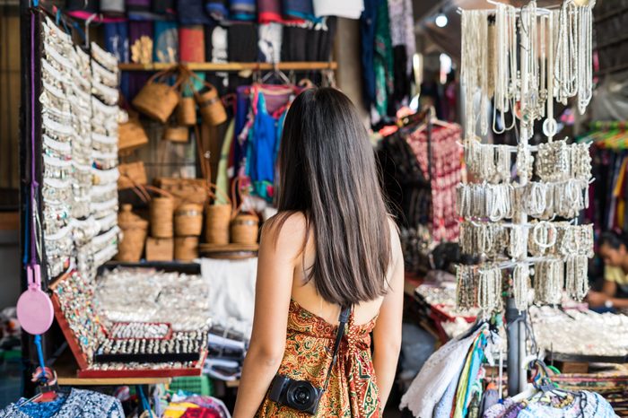 Young woman traveler looking for some souvenir at ubud market in bali