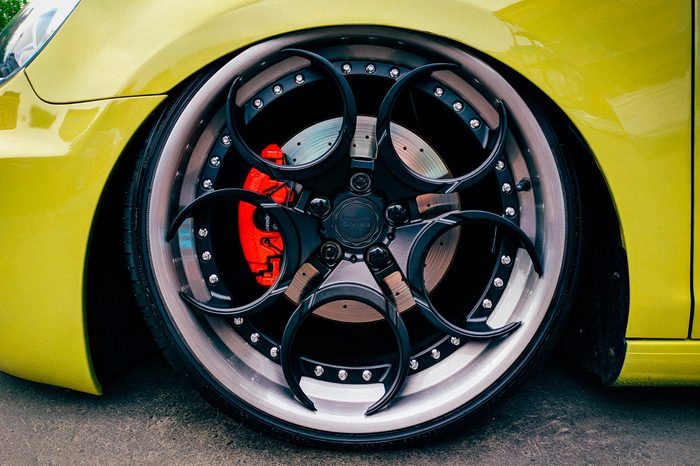 close up of custom wheels and brakes on a green car