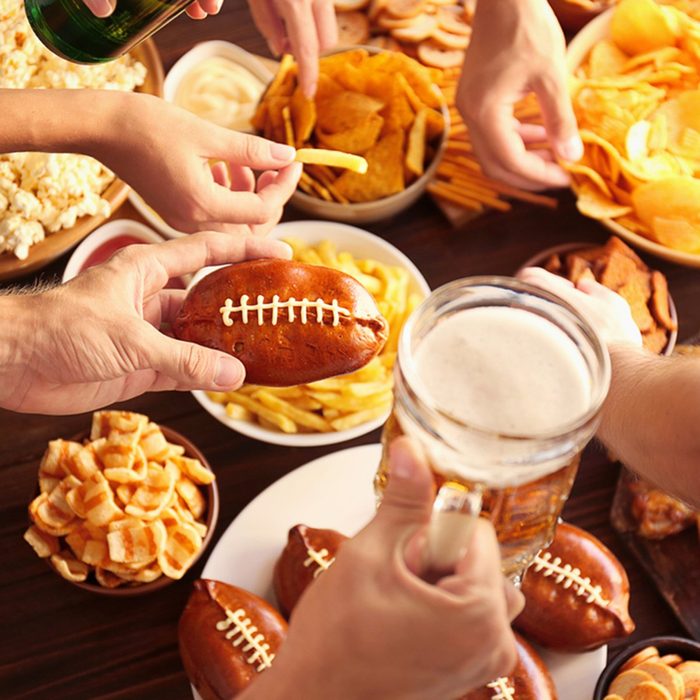 Close up view of hands taking snacks from plates during party; Shutterstock ID 552645409