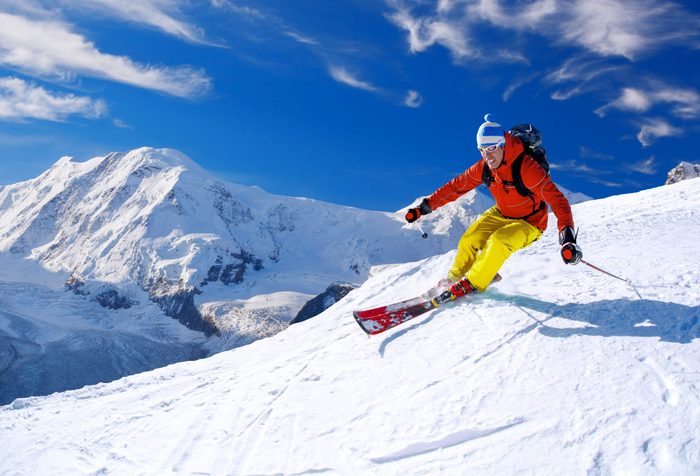 Skier skiing downhill in high mountains, Matterhorn area, Switzerland