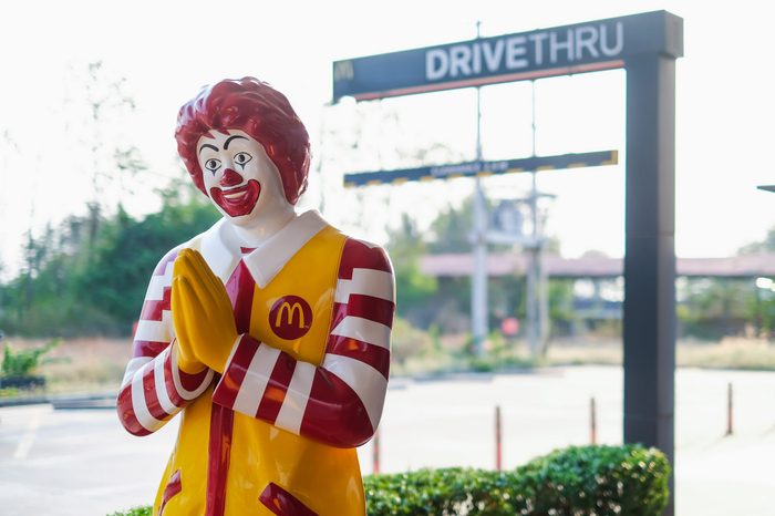 mcdonalds statue by a drive thru height clearance sign