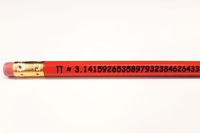 orange wood pencil with mathematical constant pi digits on white background