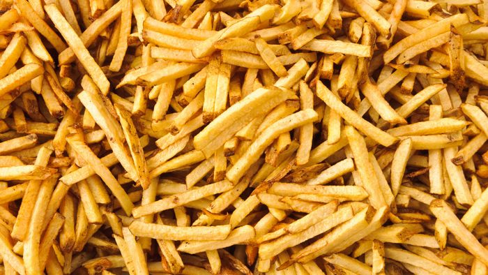 Background of cooked french fries just pulled from the deep fryer.