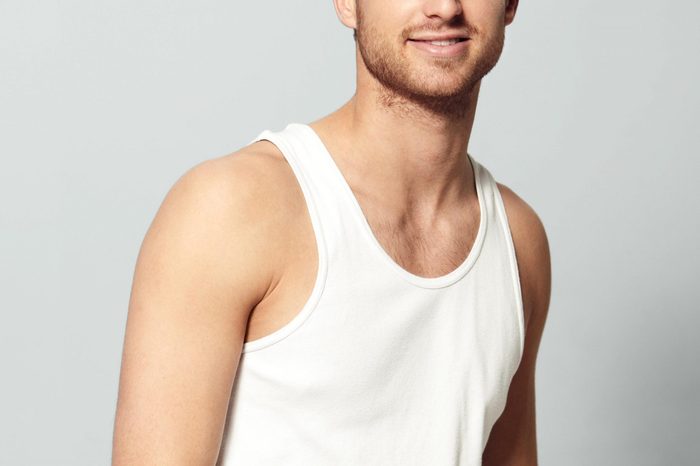 anonymous man in a white tank top. gray background