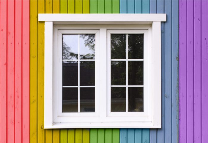 wooden wall of a house painted in a rainbow of colors