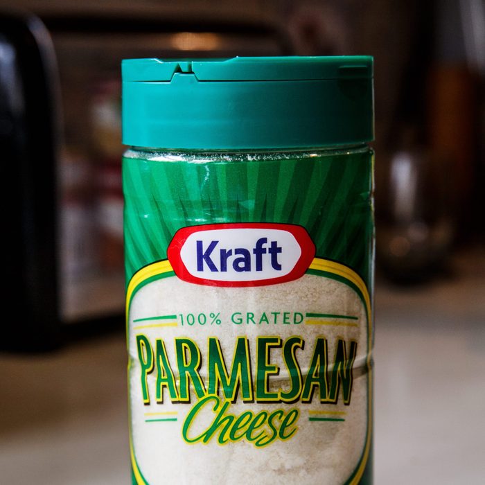 Kraft Parmesan Cheese brand in plastic shaker container. Prepared 100% grated Parmesan cheese in green packaging ready to sprinkle on food dishes.